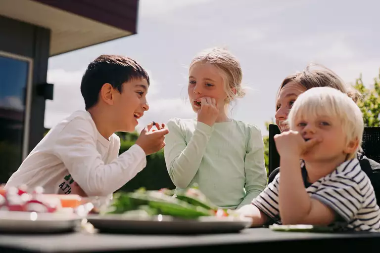 Børn, som spiser frugt udenfor